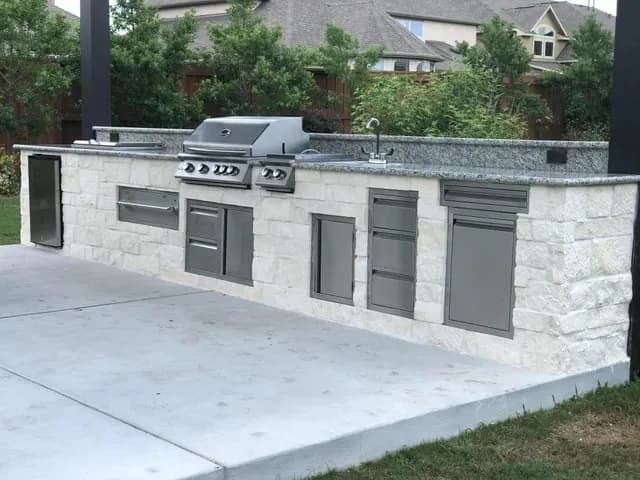 White stone outdoor kitchen grill island